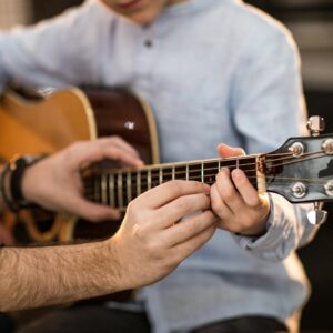 Music coach teaching guitar technique during a private lesson at Learn The Arts