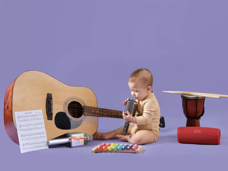 Baby exploring musical instruments including a guitar, xylophone, and drum, showing early curiosity and potential musical talent in infants