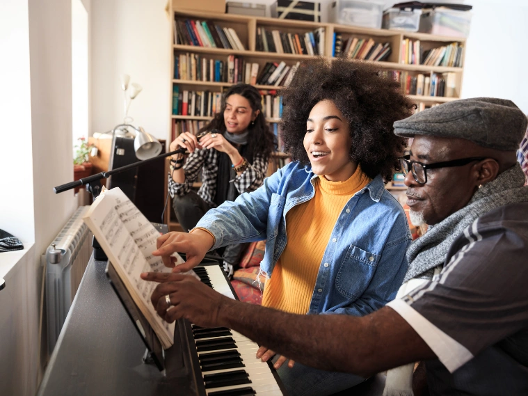 Adult student practicing vocal exercises with a voice instructor in a music studio, using a keyboard for guidance