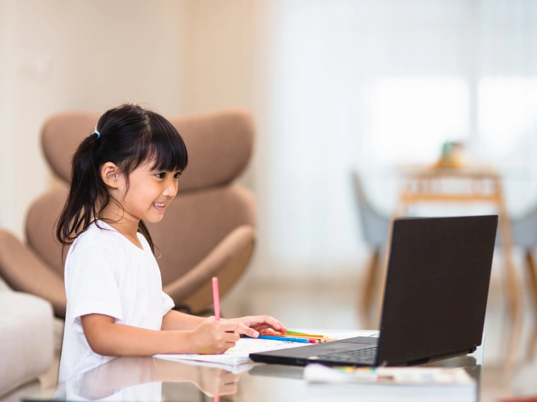 Child doing affordable online art activities at home, following drawing and painting tutorials on a tablet while completing creative projects