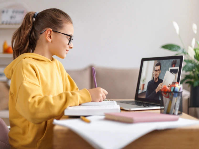 Child participating in an online art class at home, following a virtual instructor while drawing and painting with basic art supplies