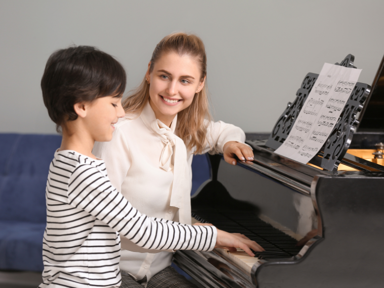A child receiving one-on-one instruction from a passionate music teacher while playing the piano, showing hands-on guidance and engagement