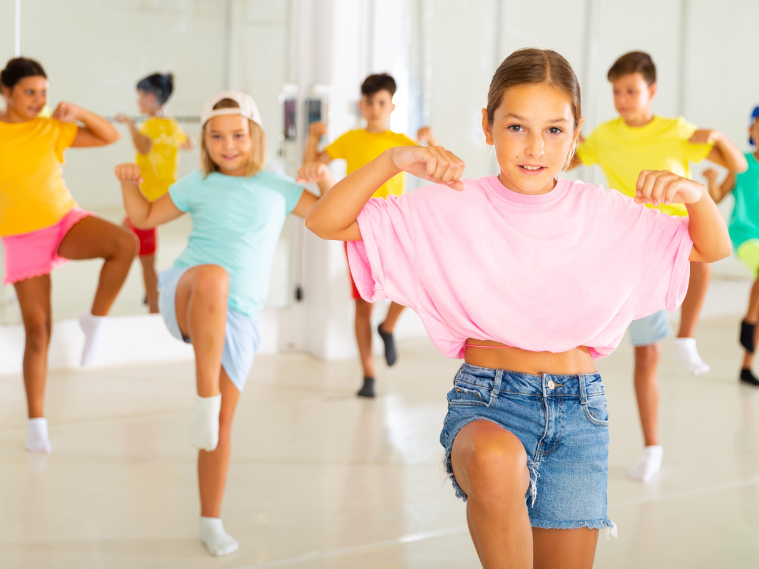 Child practicing hip hop dance steps with instructor