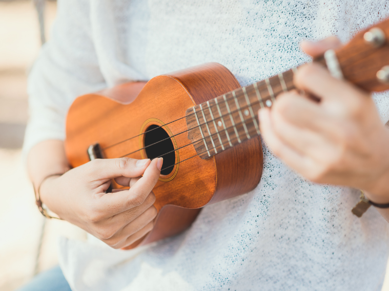 Hands playing basic ukulele chords for beginner songs