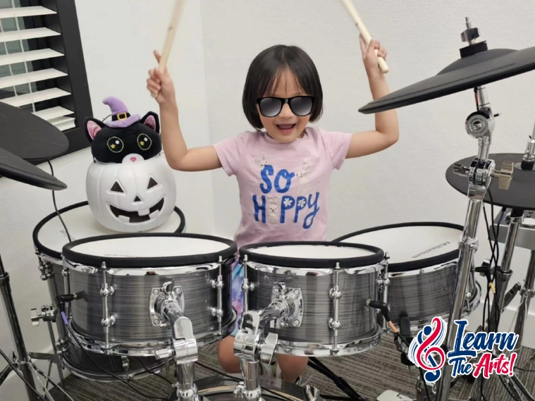 Student learning drums with an instructor during a lesson at Learn the Arts