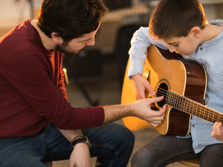 Student practicing guitar tabs in a lesson