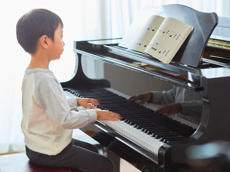 Beginner learning to use the sustain pedal on an acoustic piano