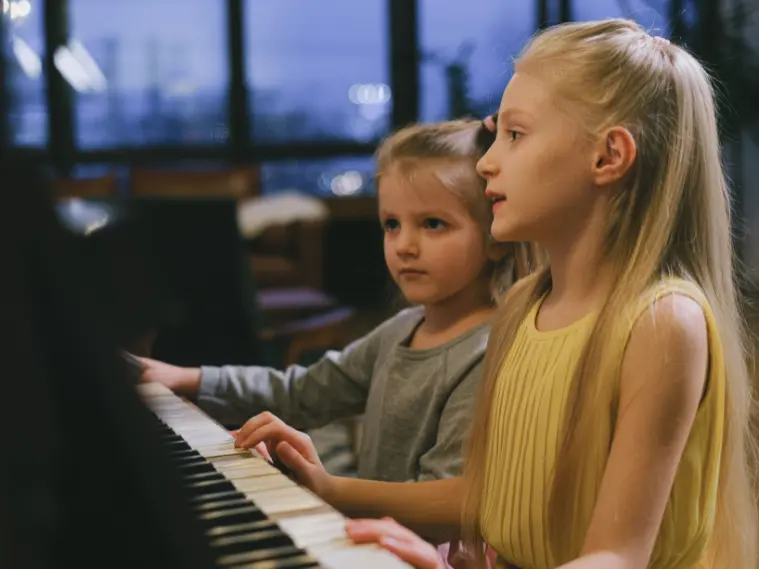 Young children learning piano during beginner piano lessons for kids