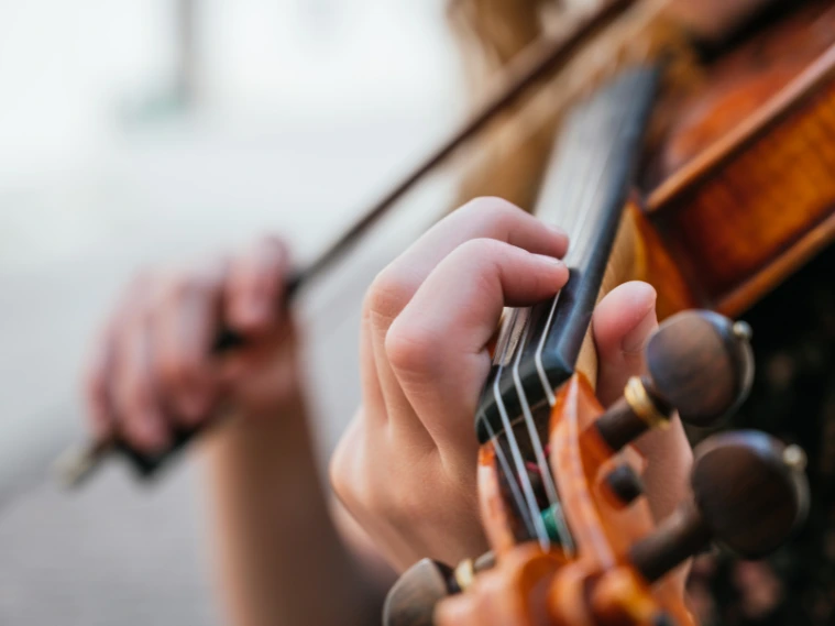 Close-up of violin finger placement on strings showing correct technique for beginners learning violin
