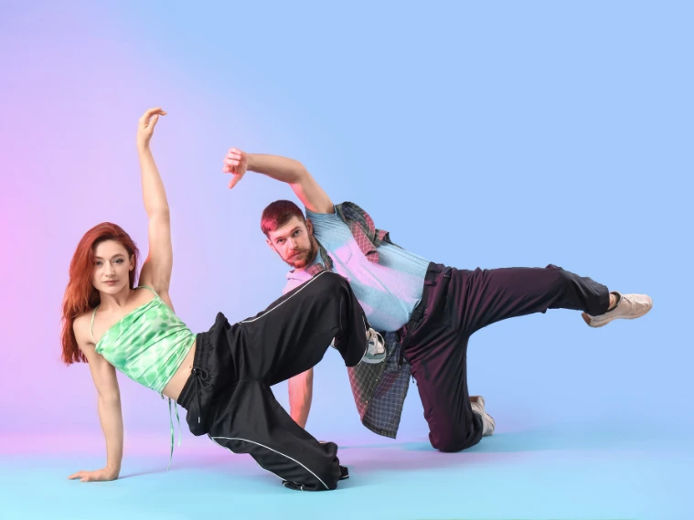 Dancers performing to energetic electronic dance music with vibrant stage lights