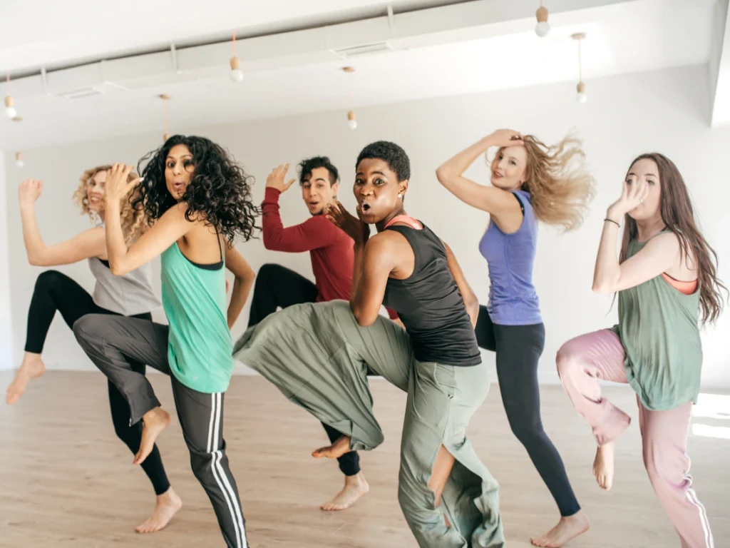 Diverse group of adults practicing dance moves in a bright studio in California focused on fitness, rhythm, and coordination training
