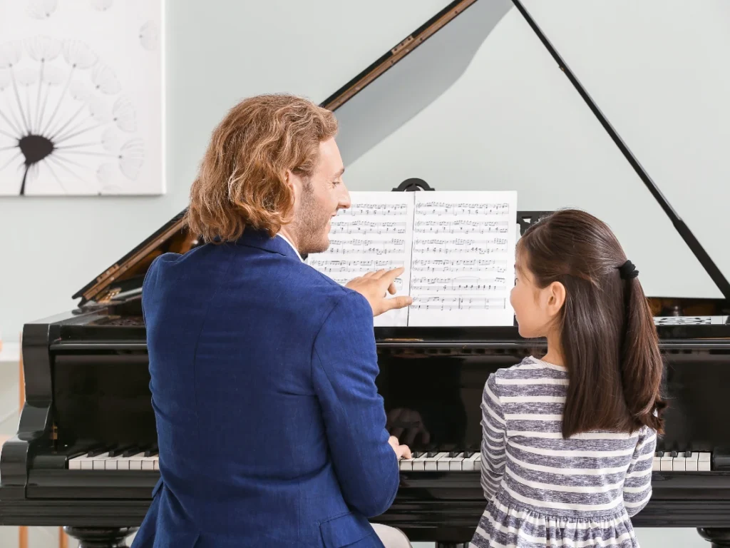 Experienced piano instructor teaching a student during a lesson in California