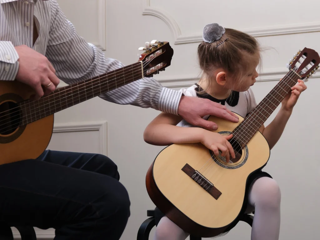 Student practicing acoustic guitar during beginner guitar lessons in Westminster, CA music studio