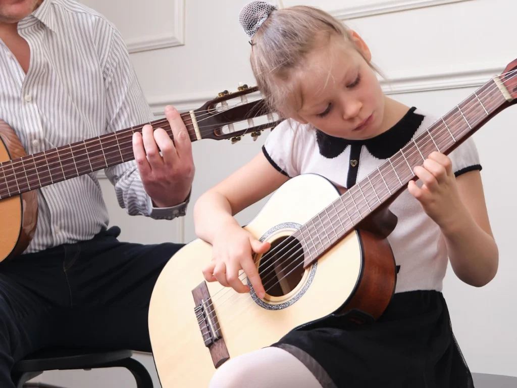 Beginner guitar student in Gilbert, Arizona learning basic chords and strumming techniques during a structured guitar lesson with an instructor