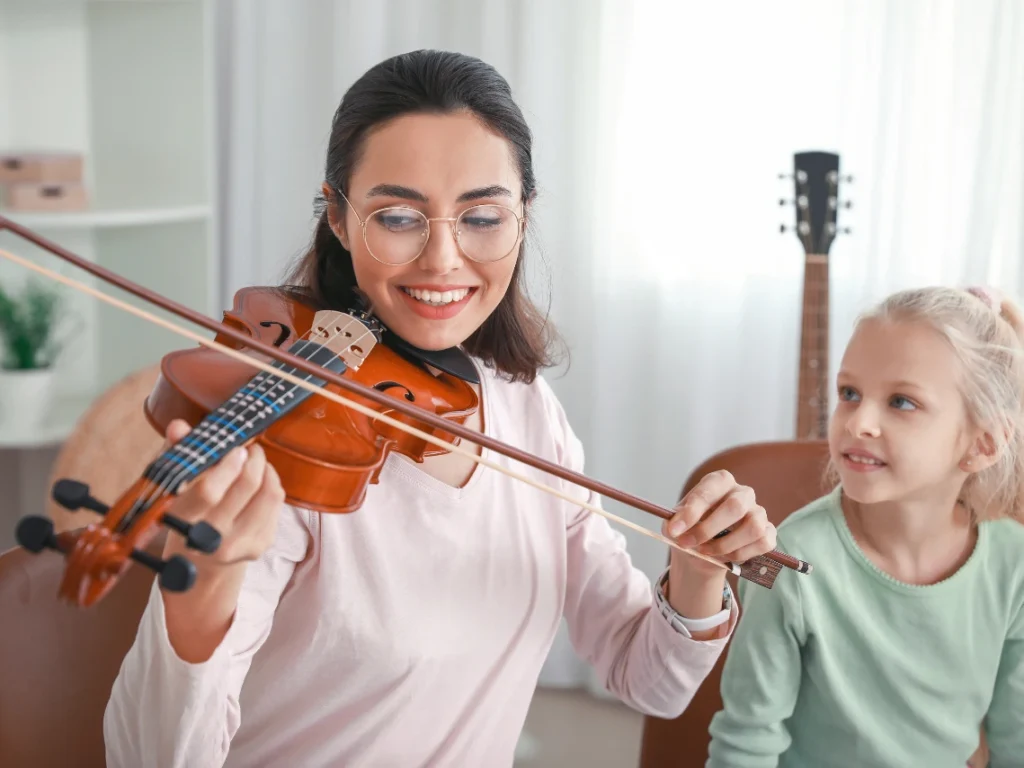 Beginner violin student in Arizona learning proper posture and bow hold during a structured music lesson with an instructor.