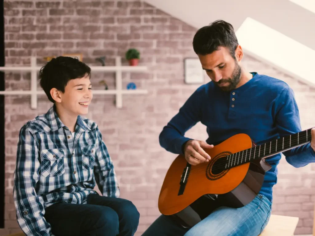 Student participating in a structured guitar program in Las Vegas, NV, practicing acoustic guitar techniques during a music lesson with a professional instructor