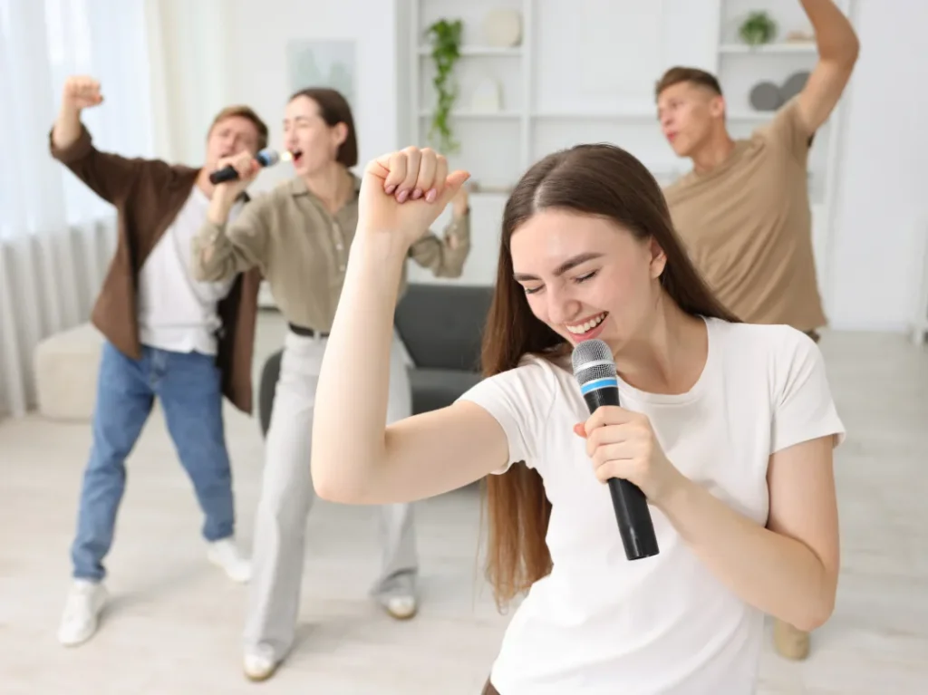 Adults singing together with microphones during an energetic group vocal lesson.