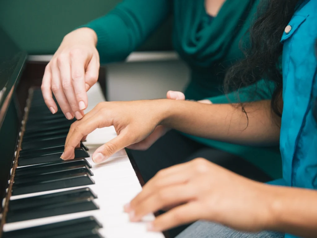 Instructor teaching proper hand position and posture during an intermediate piano lesson in Westminster, CA