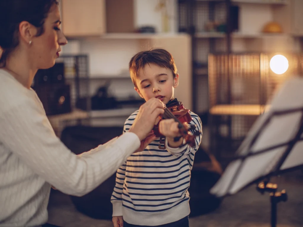 Instructor teaching proper violin posture and hand position during a beginner lesson in Gilbert, AZ