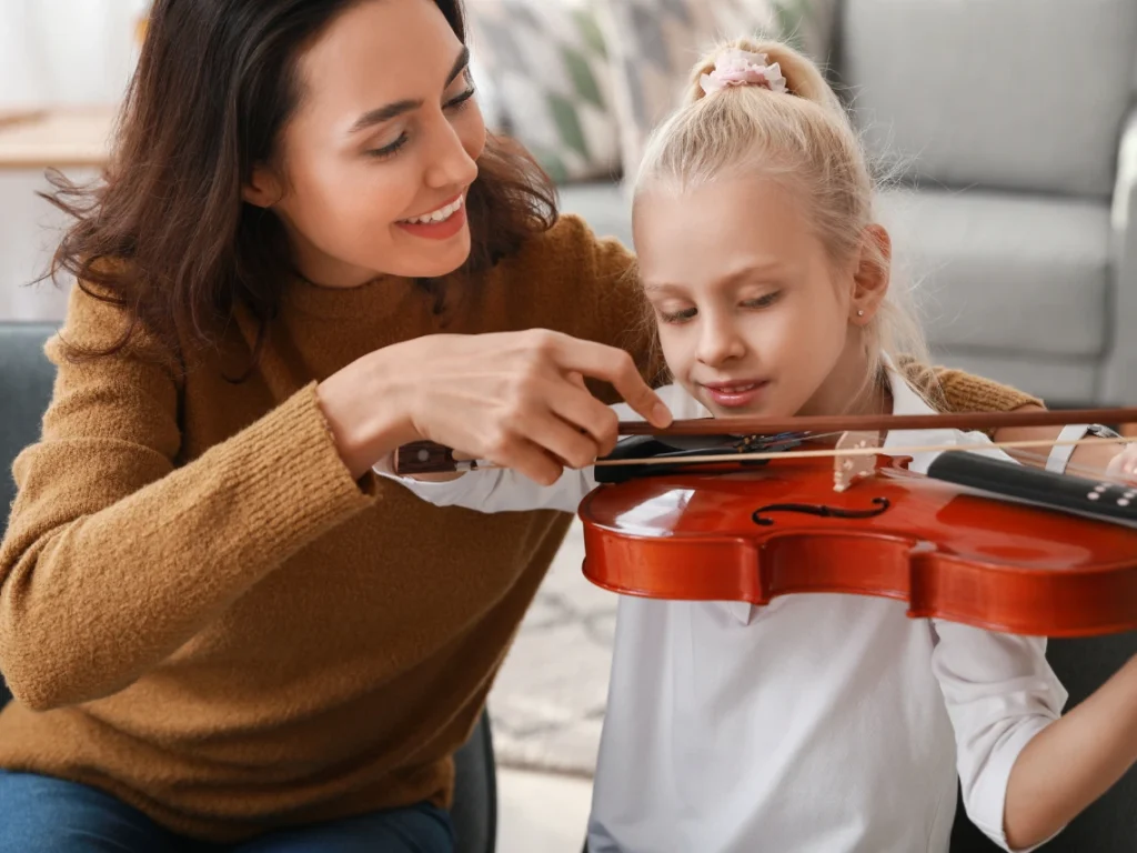 Student learning violin in a professional Gilbert, AZ music studio with an experienced instructor providing guidance on bow technique.