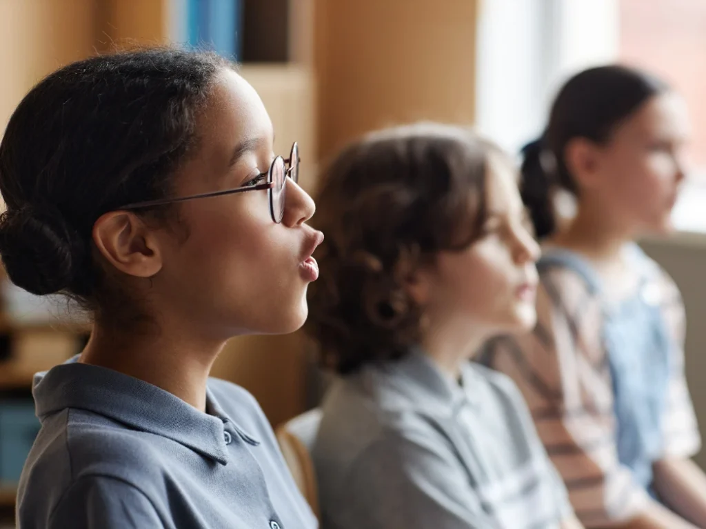 Students practicing vocal techniques together during a group singing lesson.